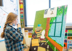 Student reviews her artwork on an easel in Kingswood Oxford's art class